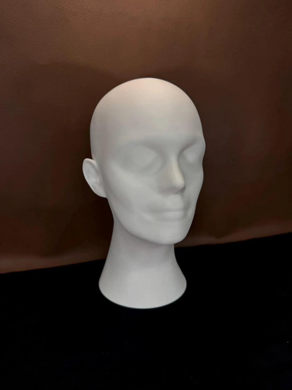 White 3D Printed head  on a brown background