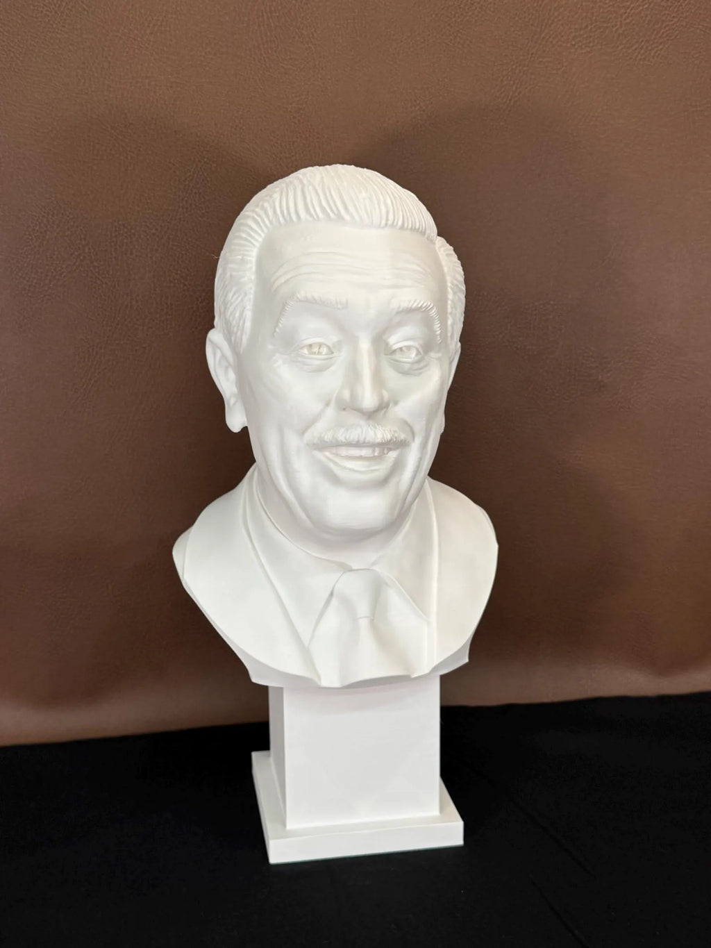 White 3D printed bust of Walt Disney on a brown background